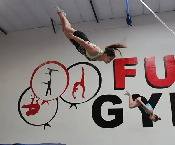 A woman is doing aerial tricks in the air