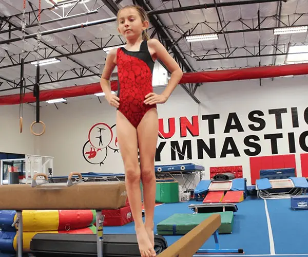 A young girl is practicing her gymnastics skills.