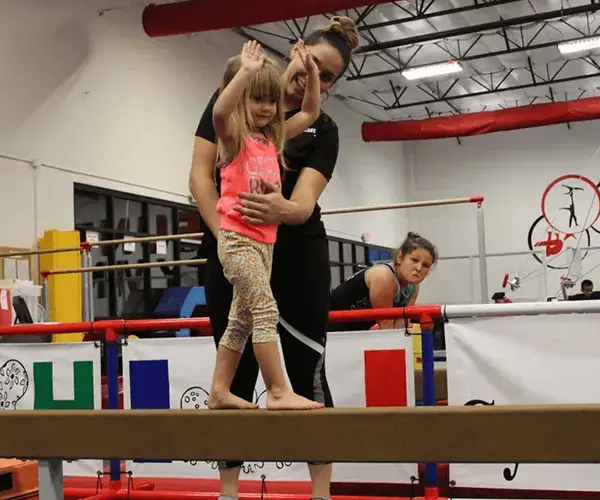 A woman and child are on the balance beam.